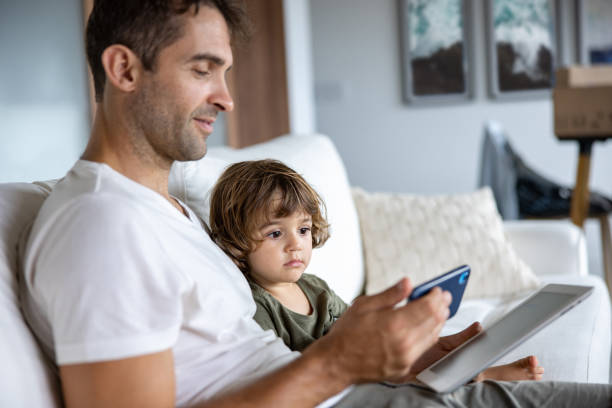 istock Father and son watching videos on a tablet and a cell phone 1479782242