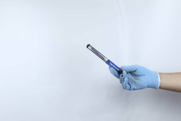 istock Gloved hand holding metal desoldering pump isolated on white background 1479783122