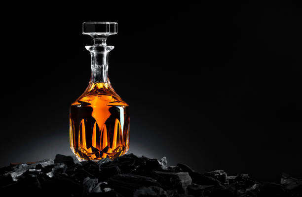 Bottle of whiskey on charcoal Bottle of whiskey on charcoal in front of a black Backround coke coal stock pictures, royalty-free photos & images