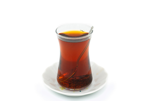 Turkish tea glass and silver spoon isolated on white