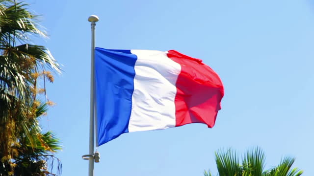 French flag in sun daylight on blue sky