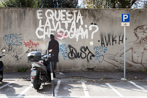 Padua, Veneto, Italy - Mar 11th, 2023: Kenny Random's 'È questa la vita que sognavi?' graffiti on a wall in Padua city center