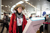 Woman using self service check-in machine at airport