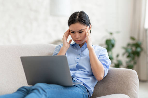 istock Exhausted asian woman working online from home 1479795264