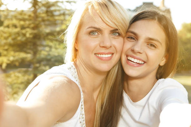 DSLR picture of mother and daughter. Isolated on white. Smiling.