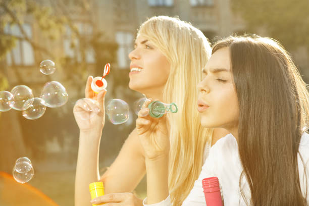 istock Mother and daughter enjoying blowing bubbles together 1479796591