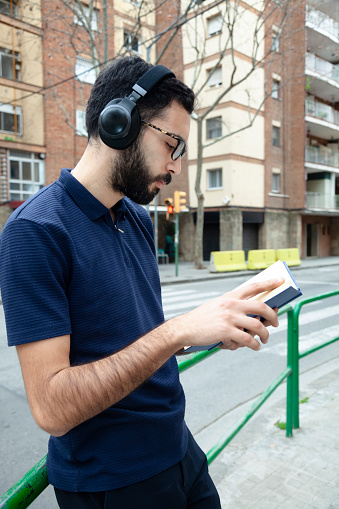 Young man using headphone on the stree