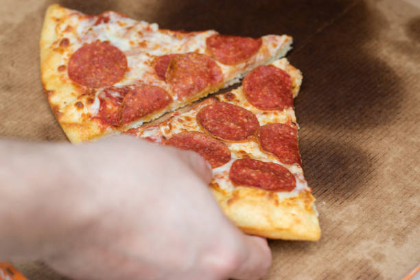 istock Hand taking a piece of pizza 1479797641