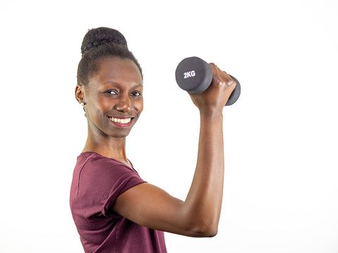 Young woman lifting a dumbbell isolated on white background