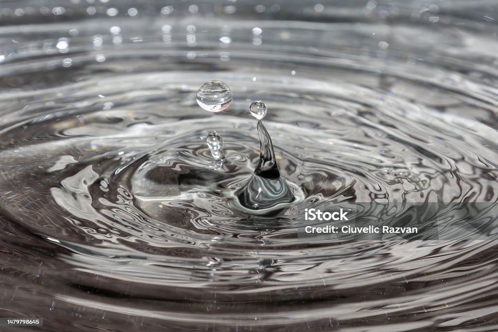 Drops of water falling into a tray Rain Stock Photo