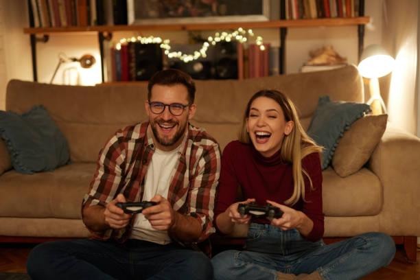 istock Young couple having fun at home playing video games 1479799205