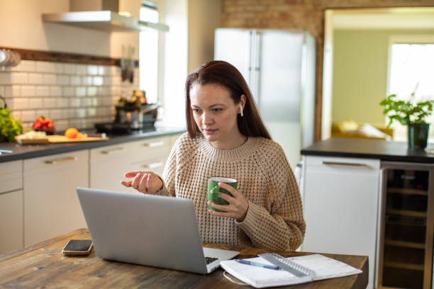 istock Young woman working on her laptop in the kitchen 1479799251