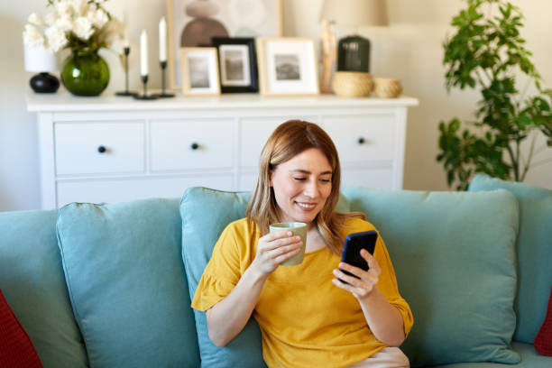 istock Woman using smartphone while drinking coffee at home in the morning 1479799252