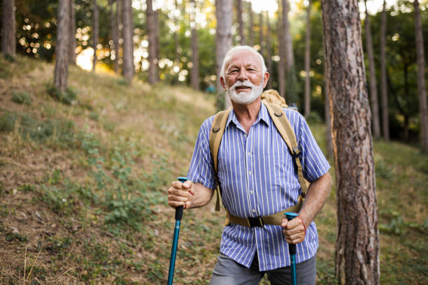 istock Senior man using hiking poles on a hike 1479799772