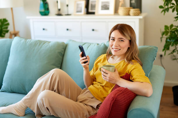 istock Woman using smartphone while drinking coffee at home in the morning 1479799778