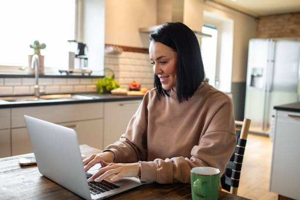 istock Young woman working on her laptop in the kitchen 1479799790