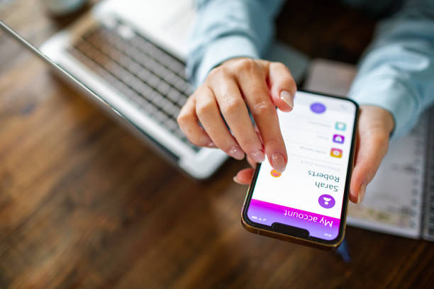istock Young woman using a banking app on her phone while working from home 1479800464