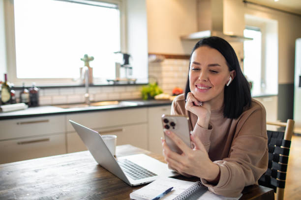 young adult woman using her phone at home - budget sverige bildbanksfoton och bilder