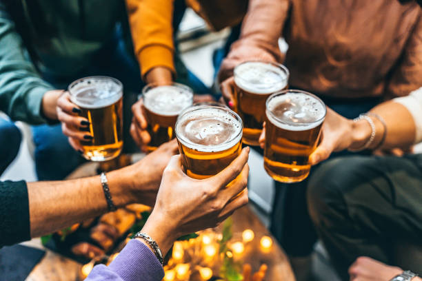 gruppe von freunden, die ein glas bier im brauerei-pub-restaurant trinken und anstoßen- glückliche multiethnische menschen, die die happy hour mit pint am stehtisch genießen- jugend-food- und getränke-lifestyle-konzept - happy hour stock-fotos und bilder