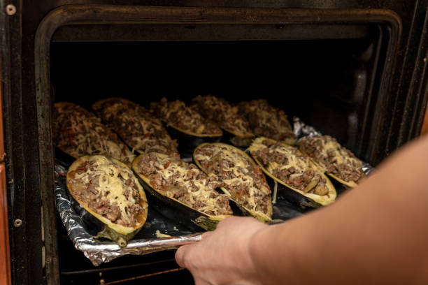 istock hostess puts a baking tray with eggplant stuffed with meat in the oven 1479801186