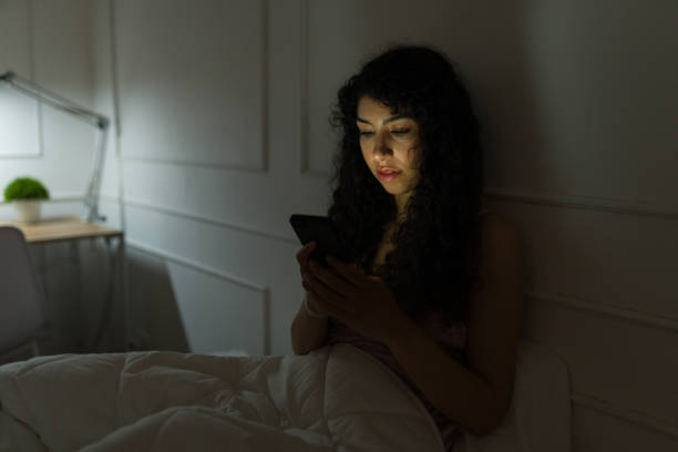 istock Happy woman texting on the phone at night before sleep 1479803803