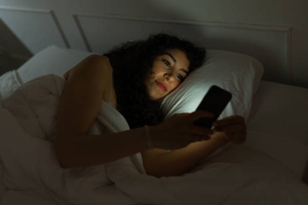 istock Smiling beautiful woman in bed using her phone 1479803868