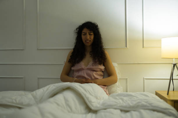istock Upset woman feeling sick on her stomach in bed 1479804921