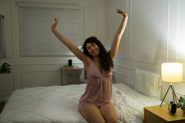 istock Relaxed happy woman waking up and stretching in bed 1479804942