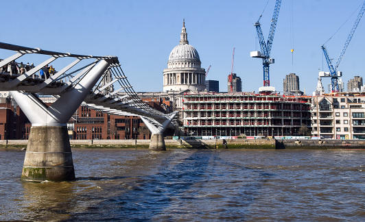London, UK - April 4 2023: Millennium Bridge, St Paul's Cathedral, and River Thames on a clear sunny day.