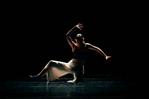 istock Young girl performing contemporary dance on dark stage. 1479807935