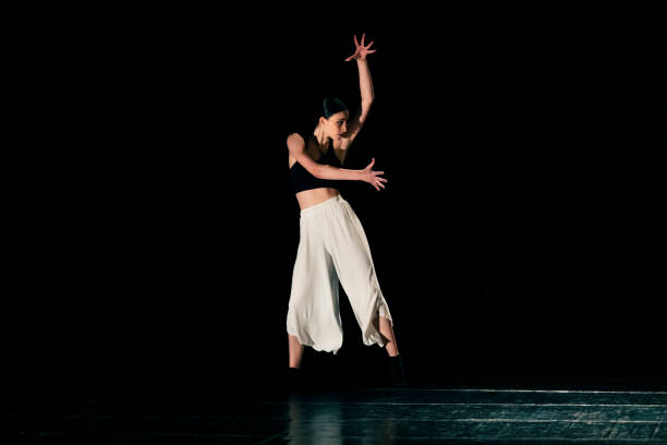 istock Young girl performing contemporary dance on dark stage. 1479807969