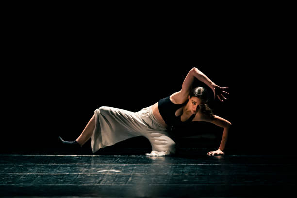 istock Young girl performing contemporary dance on dark stage. 1479807986