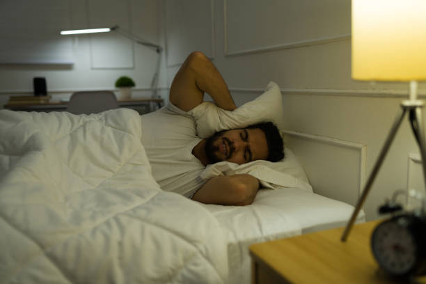 istock Stressed man trying to sleep with loud music 1479808516