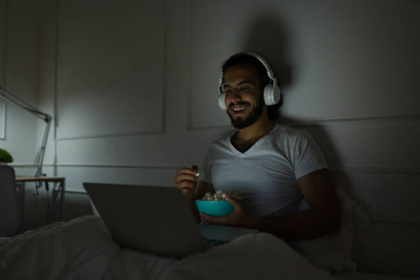istock Handsome man enjoying a movie late at night 1479808825