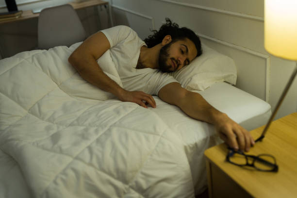 istock Tired man waking up and searching for his glasses 1479809326