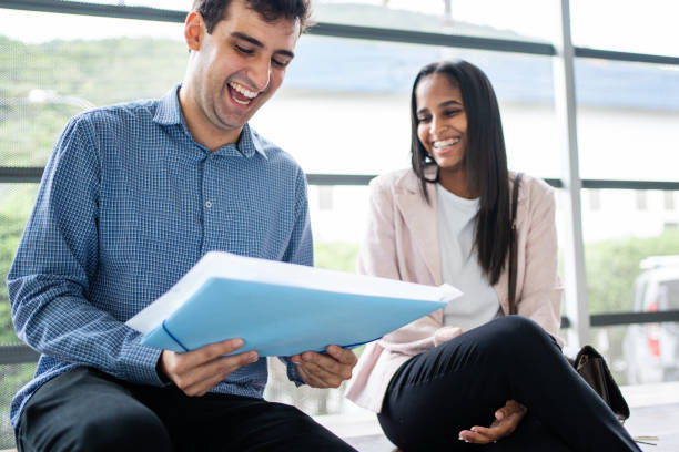 istock Happy business colleagues discussing paperwork and smiling at office 1479809914