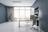 Bright blue home office interior with furniture, white flooring, window with city view and curtain, bookshelf. 3D Rendering.