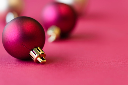 Pink  colored christmas baubles on pink background.