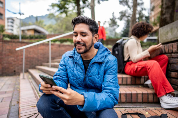 istock Young man using mobile phone on stairs outdoors 1479824196