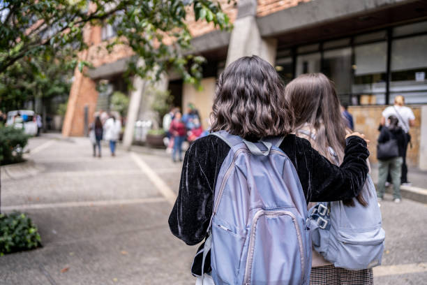 rückansicht von studienfreunden, die an der universität ankommen - university education walking teenage girls stock-fotos und bilder