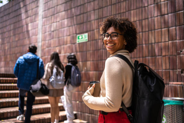 portrait d’une jeune étudiante montant les escaliers - étudiant en université photos et images de collection