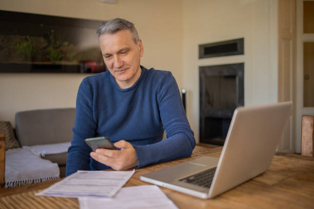istock Mature man using calculator while going through bills and home finances 1479827610