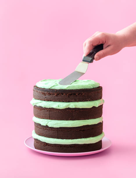 istock Making chocolate layer cake with mint flavor cream, isolated on a pink background 1479828149