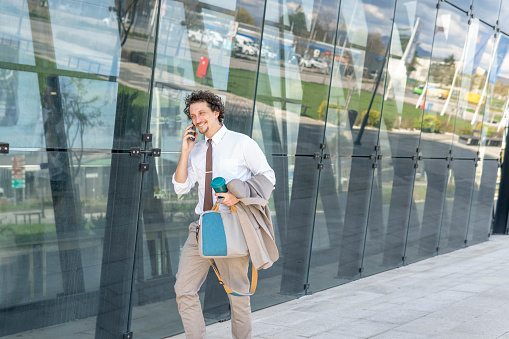 Handsome businessman on his way for work drinking coffee on the way