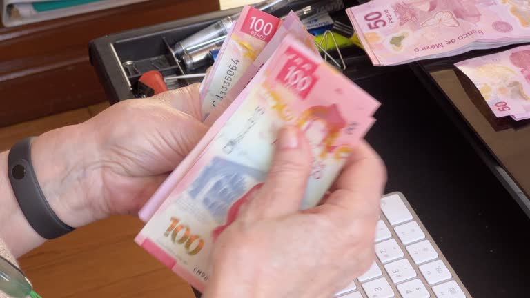 Senior woman counting money, Mexican pesos