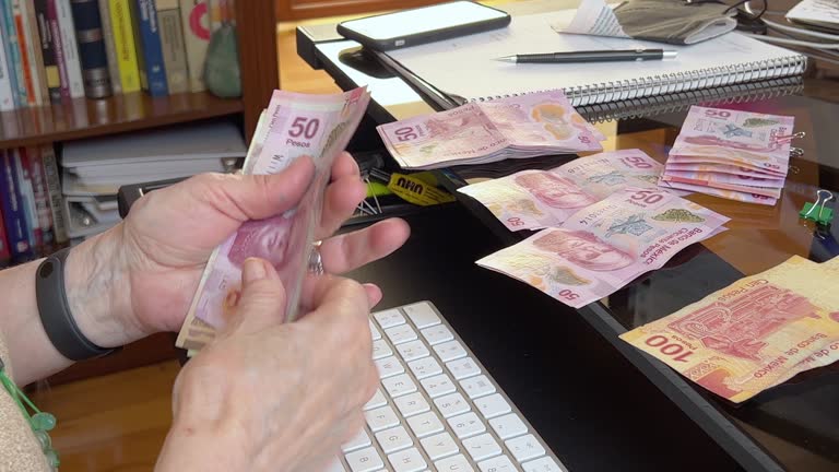 Senior woman counting money, Mexican pesos