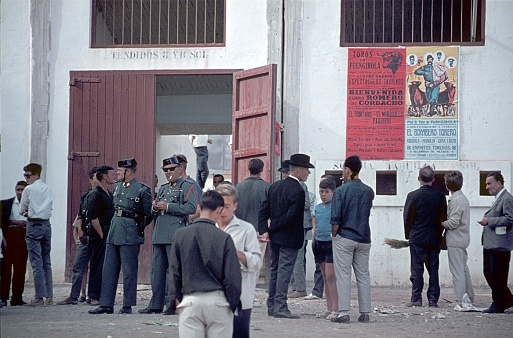 Malaga, Andalusia, Spain, 1964. Local people and members of the Civil Guard in front of a bullfighting arena in Malaga.