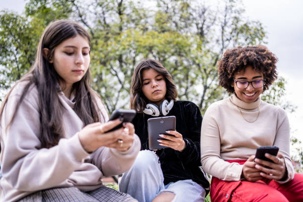 istock Young friends using mobile phone/digital tablet outdoors 1479837199