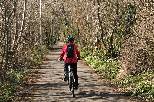 Haddington, Scotland - 3 April 2023:  A cyclist is cycling along a cycle route near Haddington on a sunny spring day.