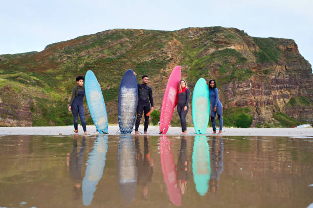 istock Four surfer friends standing with their surfboards at the seashore 1479846422